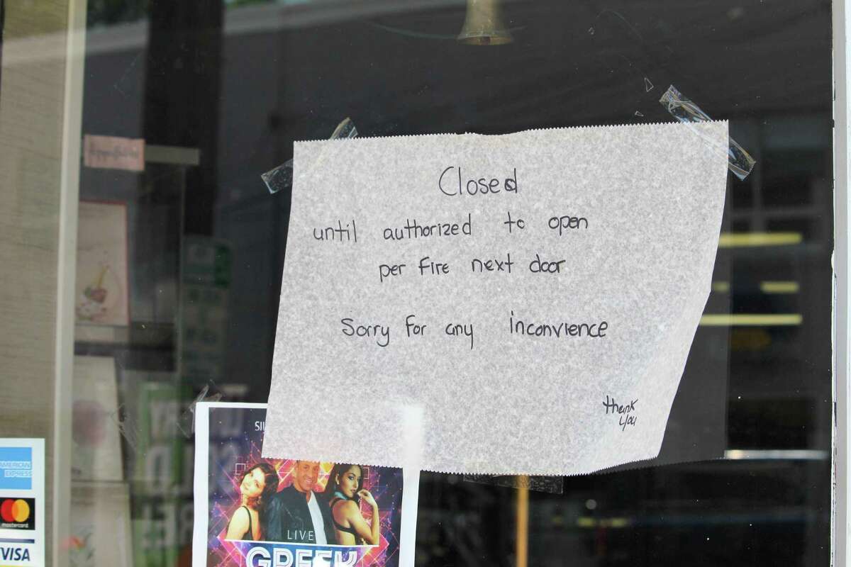 A handwritten sign in the front door of Steve's Market on Thursday, July 5, 2018 advises customers that the business was closed due to the fire next door.
