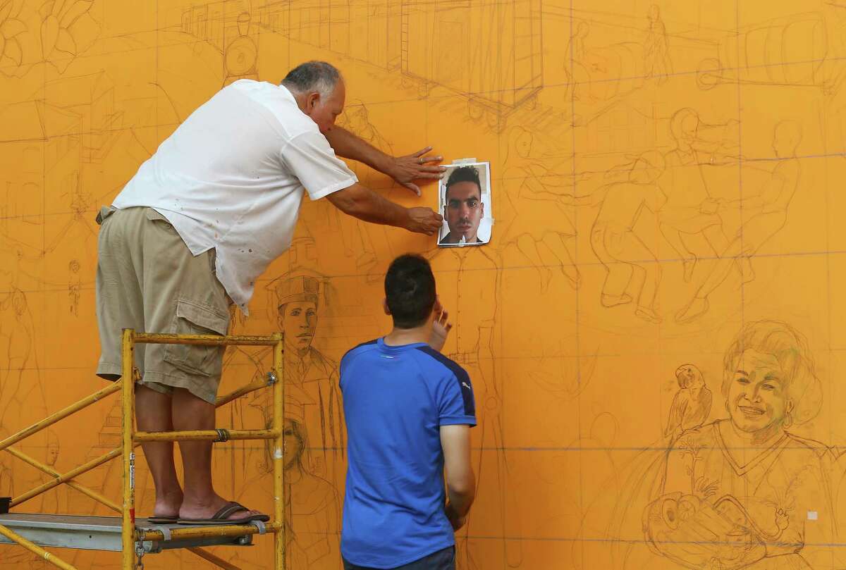 Jesse Sifuentes Jr., left, and his son Jesse Sifuentes III work on a mural titled “Mexican-American History and Culture in 20th century Houston” on a facade of the Heritage Society Museum.