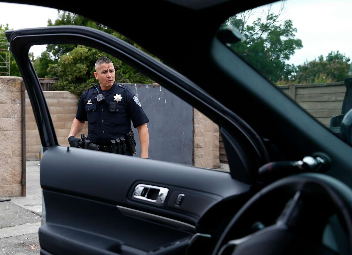 Officer Elias Castro returns to his police cruiser while searching for a burglary suspect in Fairfield, Calif. on Friday, July 6, 2018. Homicide rates have declined throughout the Bay Area including Fairfield, the county seat of Solano County.