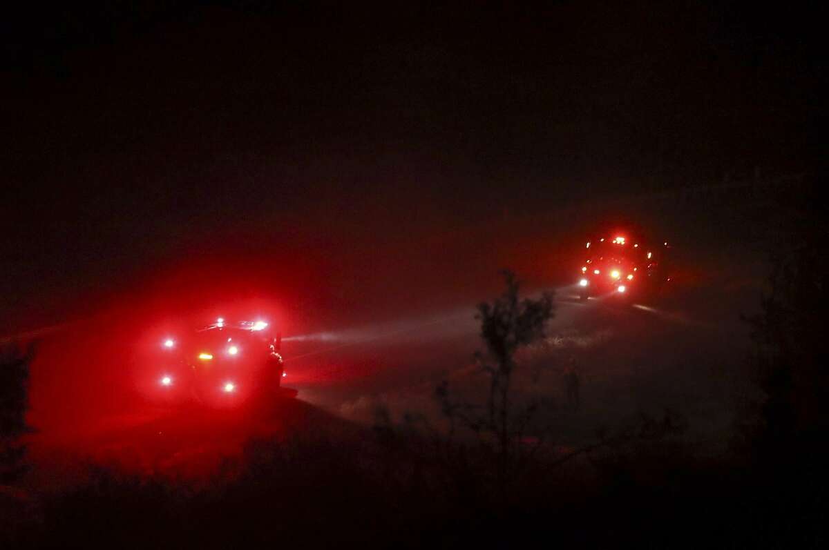 In this photo taken Thursday, July 5, 2018, fire crews work on a hot spots at the Klamathon Fire near Interstate 5 and Hornbrook, Calif. The wildfire burning through drought-stricken timber and brush near California's border with Oregon has killed one person and destroyed multiple structures as it grows largely out of control, authorities said Friday.