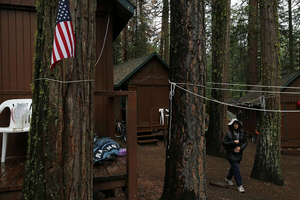 Michelle Tom walks through the trees from her cabin to find her family July 9, 2015 at Mather Family Camp in Groveland, Calif.