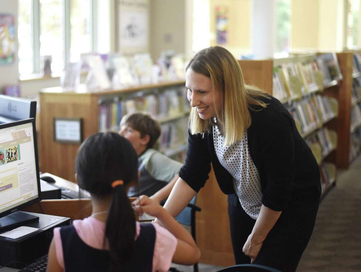 New Cos Cob Library Branch Manager Laura Matthews helps young readers in the Cos Cob Library in the Cos Cob section of Greenwich, Conn. Wednesday, July 5, 2018. Matthews plans to take a forward-thinking approach to her duties as she replaces Wendy Silver, who retired after 39 years as Branch Manager earlier this year.