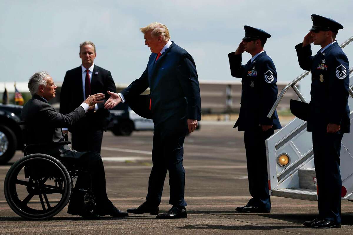 President Donald Trump shakes hands with Gov. Greg Abbott after landing at Ellington Field Joint Reserve Base in Houston in May 2018. The Texas Republican Party, concerned about the “polarizing nature of the President,” has privately called for setting up a contingency budget to encourage people who refuse to vote for the president to vote for Republican candidates for U.S. Senate and state legislative races.