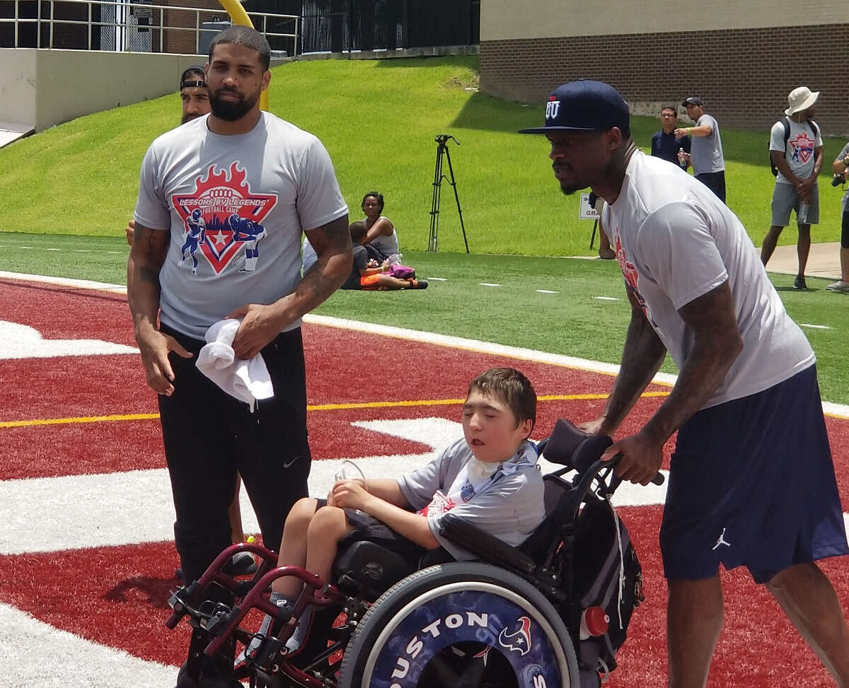 Retired Texans Andre Johnson and Arian Foster hosted Lessons by Legends youth football camp to youngsters.