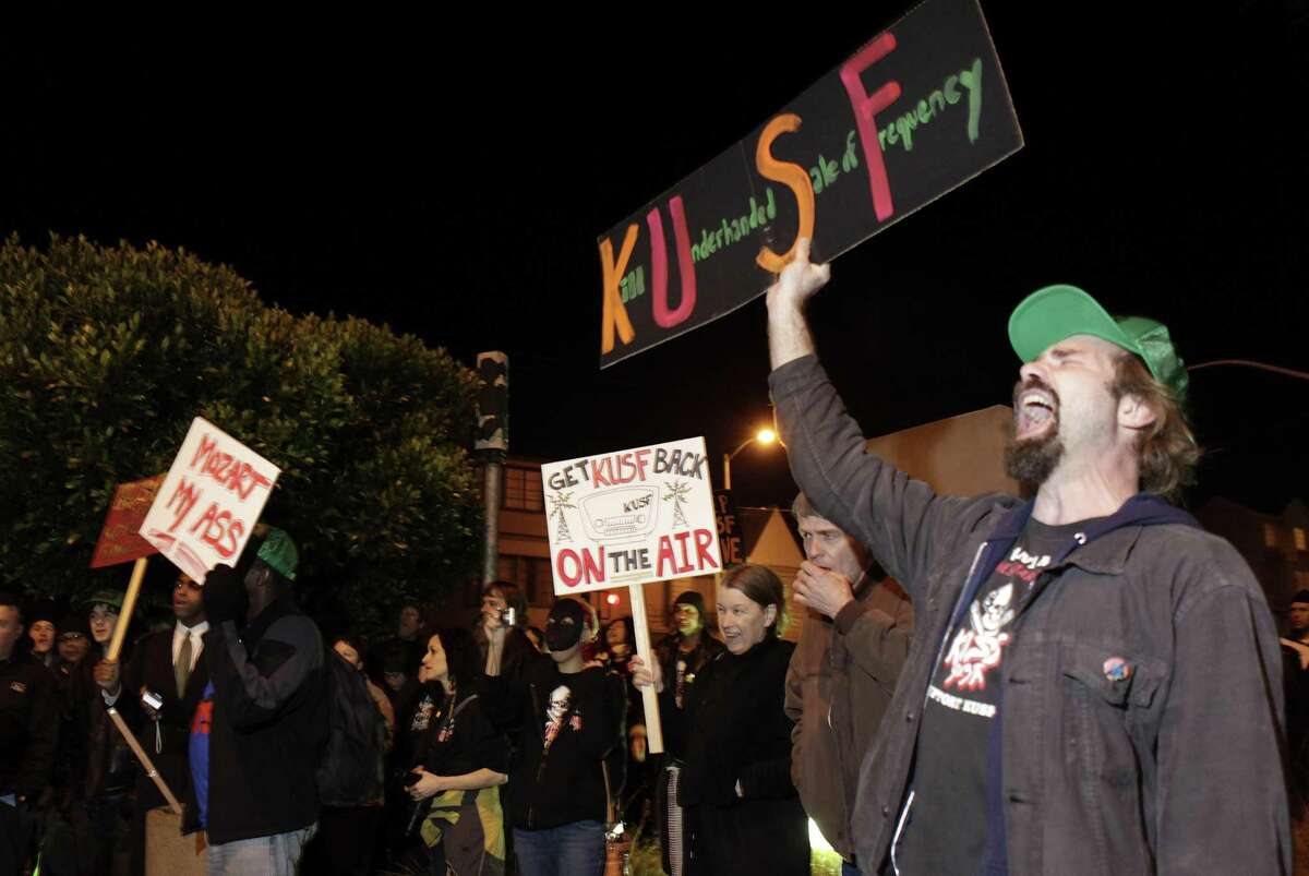 Top: DJ Henry Wimmer does his streaming show at the new home of KXSF. Right: Jay Jaworski (right), a KUSF volunteer, joins protest ers in 2011, objecting to the University of San Francisco’s decision to shut down the station. Volunteers regrouped to establish KXSF, which will begin broadcasting in a few weeks.