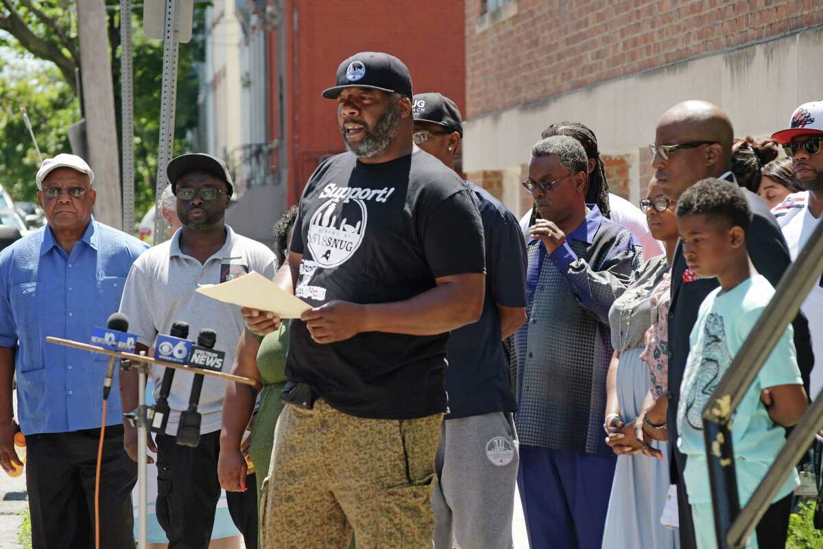 Jerome Brown, at podium, director of Albany 518 SNUG, a program under Trinity Alliance, talks about the death of SNUG worker, Elijah Cancer, during a press conference outside of Trinity Alliance on Sunday, July 8, 2018, in Albany, N.Y. Cancer was shot and killed early Saturday morning in the South End. (Paul Buckowski/Times Union)