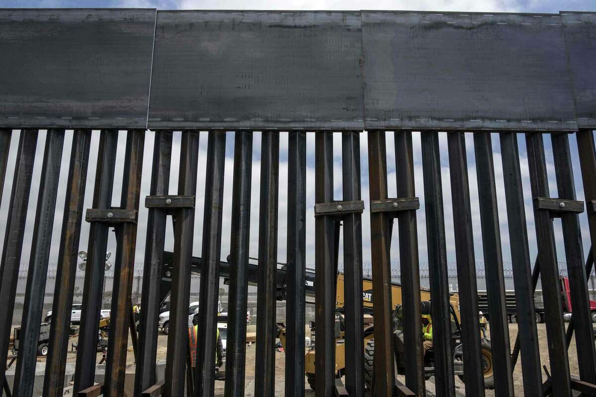 Trabajadores en Mesa de Otay, San Diego, California, en Estados Unidos, reemplazan una sección del muro entre Méxicoy Estados Unidos, visto desde Tijuana.