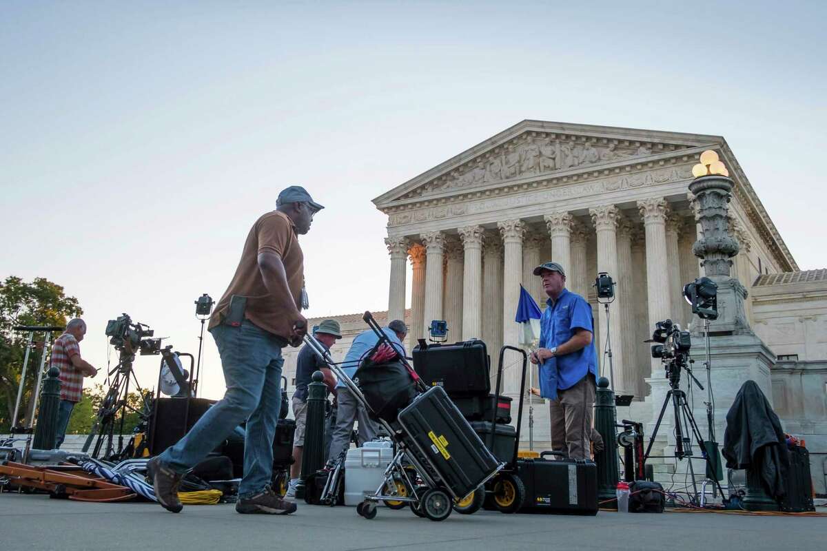 News crews set up in front of the U.S. Supreme Court early Monday morning, July 9, 2018, in Washington. President Trump is expected to announce his choice for Supreme Court Justice Monday evening.