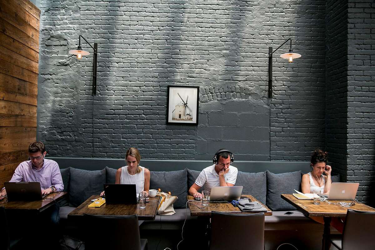 Members of Spacious work from the dining area of The Milling Room, in New York, June 29, 2018. Spacious, a membership-based startup, converts upscale restaurants into weekday workspaces. (Sam Hodgson/The New York Times)