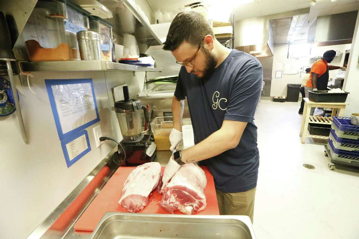 Chef Felipe Riccio of Goodnight Charlie's cuts the pork he uses to make cochnita pibil.