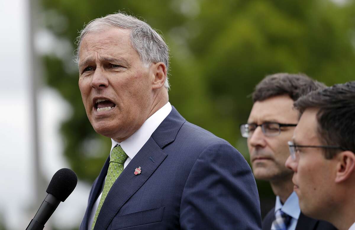 Washington Gov. Jay Inslee, right, speaks as Attorney General Bob Ferguson, center, and Solicitor General Noah Purcell look on at a news conference announcing a lawsuit against the Trump administration over a policy of separating immigrant families illegally entering the United States, in front of the Federal Detention Center Thursday, June 21, 2018, in SeaTac, Wash. Ferguson made the announcement outside the federal prison south of Seattle, where about 200 immigration detainees have been transferred � including dozens of women separated from their children under the administration's "zero tolerance" policy. (AP Photo/Elaine Thompson)