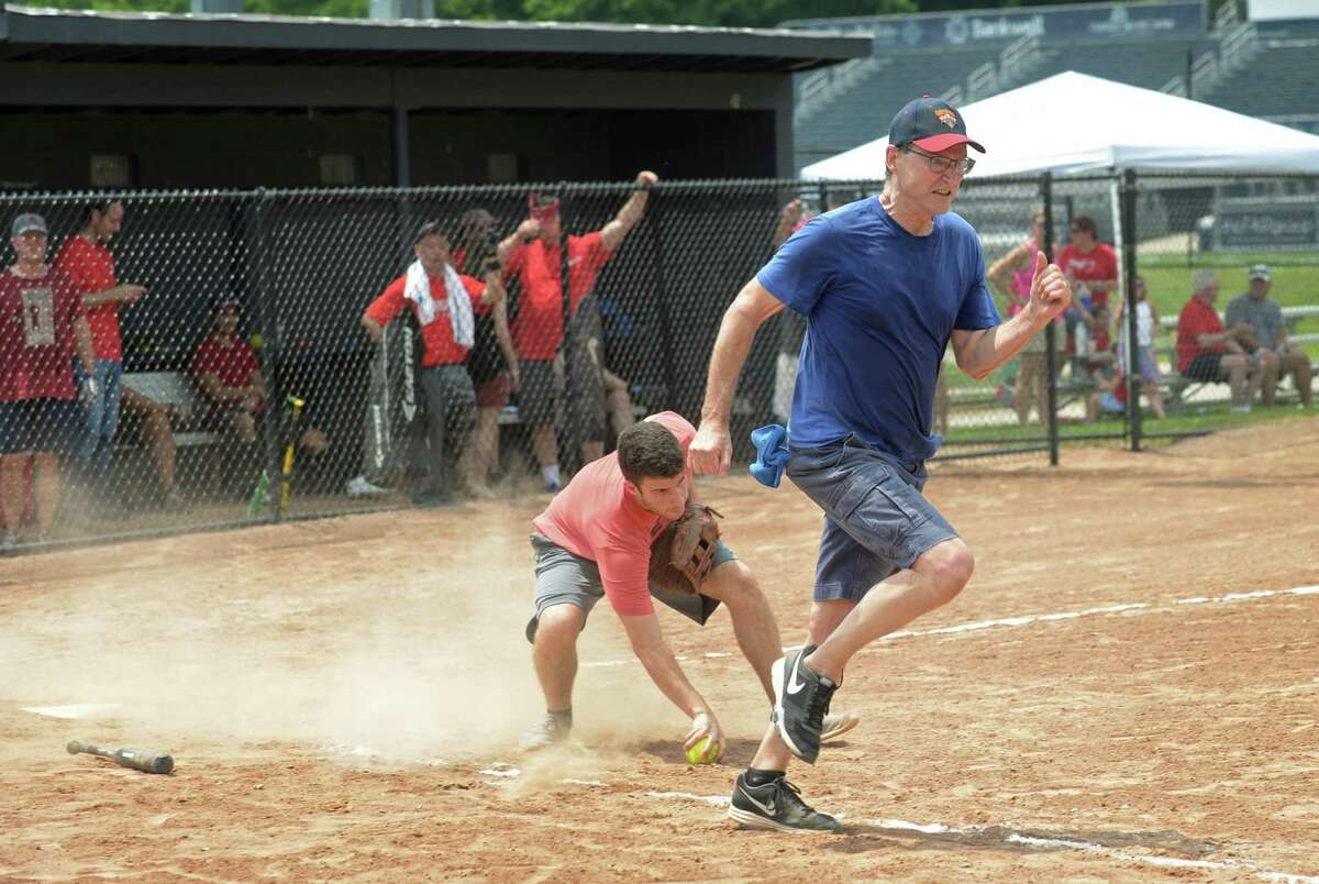 Republican catcher Luke Terradista handles a bunt by Democrat Bob Sabo during the annual Wilton Frivolity Bowl Wednesday, July 4, 2018, where town Republicans and Democrats face off during a friendly game of softball at Wilton High School in Wilton, Conn.