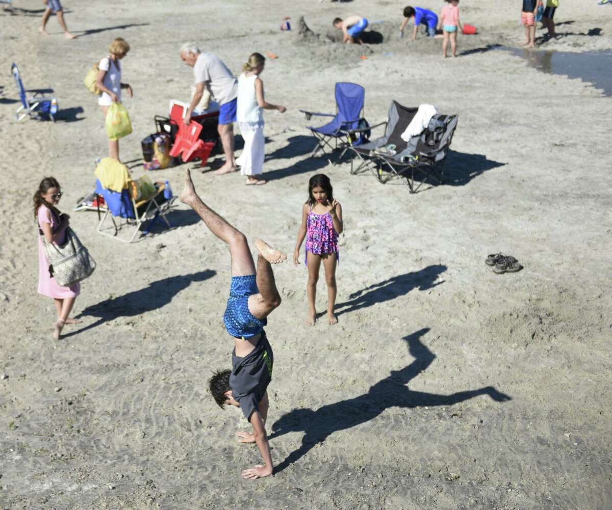 Greenwich's Hudson Moskowitz-Maione does a handstand on the beach at Greenwich Point Park in Old Greenwich, Conn. Saturday, July 7, 2018.