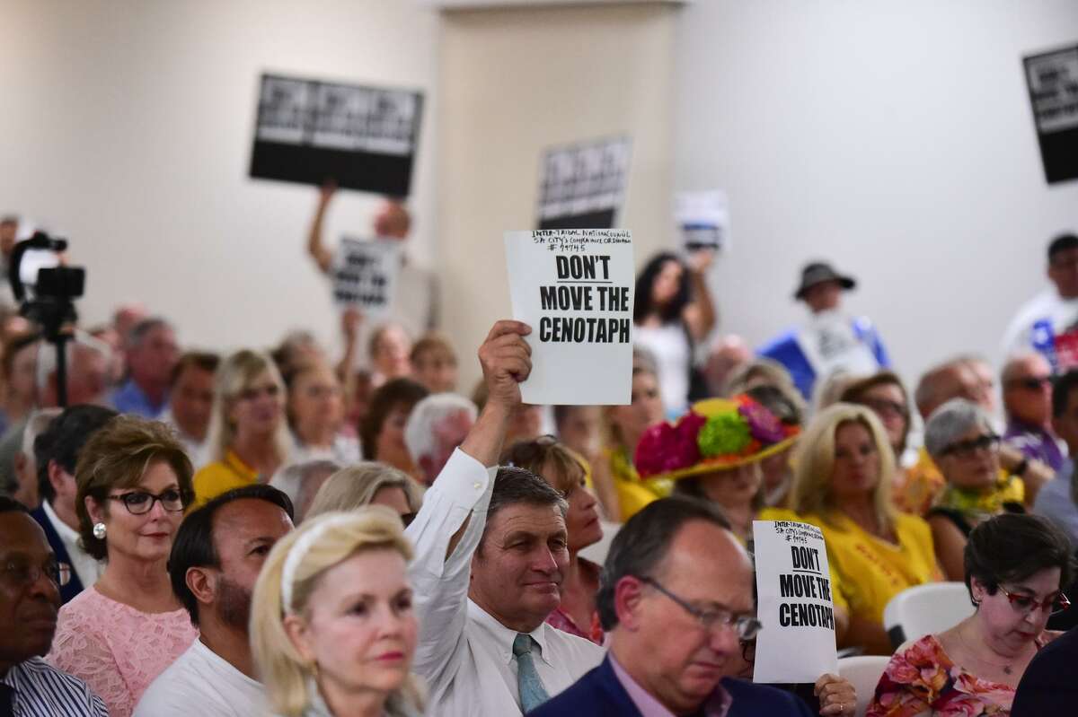 A man holds a sign during a community meeting about the proposed redevelopments to Alamo Plaza that was held last month at the San Antonio Garden Center.