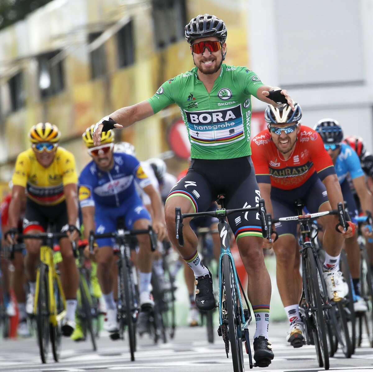 Slovakia's Peter Sagan, wearing the best sprinter's green jersey, crosses the finish line ahead of Italy's Sonny Colbrelli, second right, Belgium's Philippe Gilbert, second left, and Belgium's Greg van Avermaet, left, to win the fifth stage of the Tour de France cycling race over 204.5 kilometers (127 miles) with start in Lorient and finish in Quimper, France, Wednesday, July 11, 2018. (AP Photo/Christophe Ena)