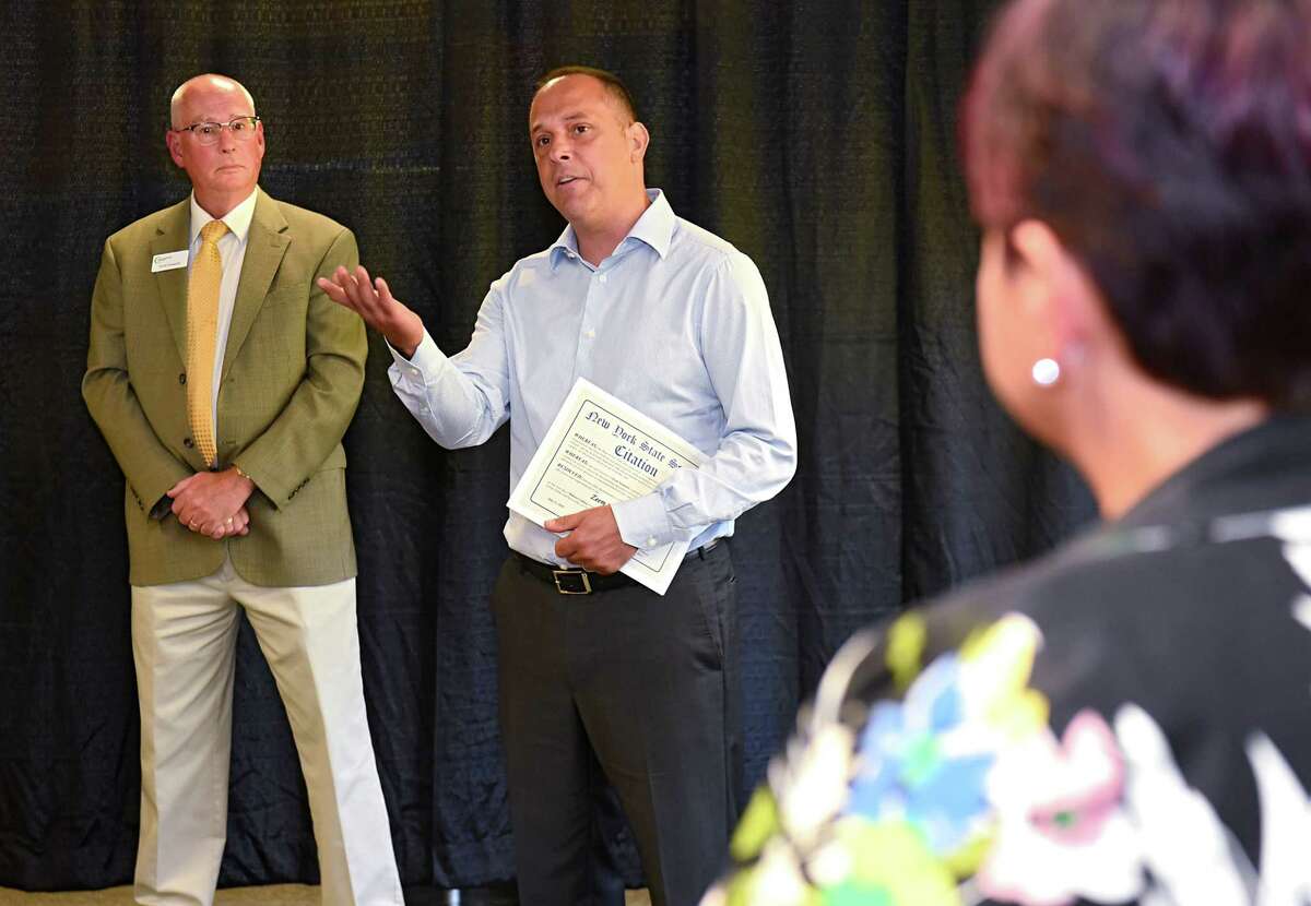Zeem Solutions CEO Paul Gioupis, center, speaks during a ribbon cutting celebration at Zeem Solutions on Wednesday, July 11, 2018 in Schenectady, N.Y. Scott Osswald of Capital Region Chamber listens at left. Councilwoman Leesa Perazzo listens at right. Zeem is a service provider that offers validated Commercial Electric VehicleOs for fleet operators in the USA. (Lori Van Buren/Times Union)