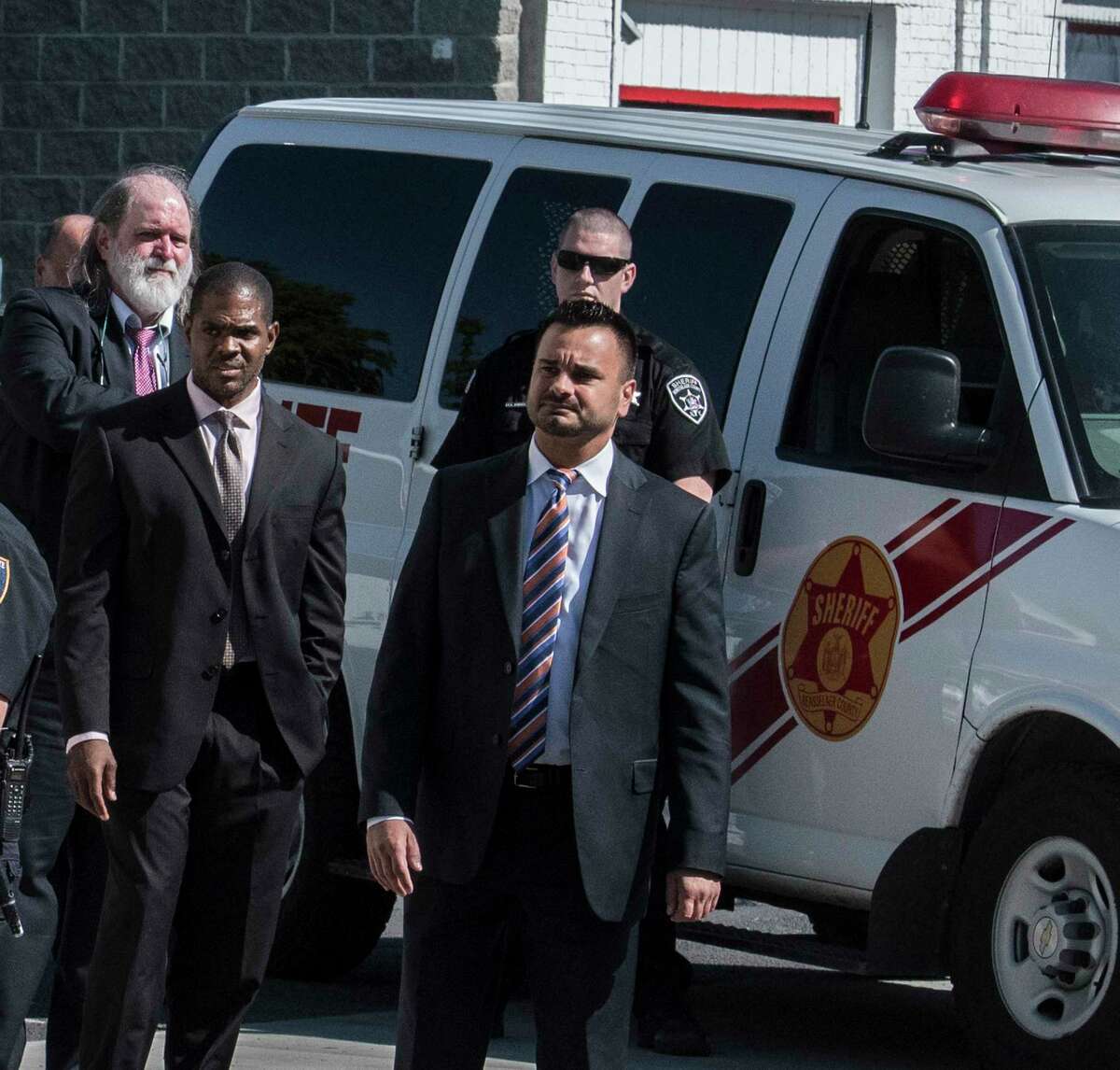 With a significant security detail New York State Supreme Court Judge Andrew Ceresia, center, looks south on 5th Avenue as a prisoner van containing Richard Wright, background, sits in sight of the entourage during a tour of the structures that were involved with the murder and arson case of Richard Wright Thursday July 12, 2018 in Troy, N.Y. (Skip Dickstein/Times Union)