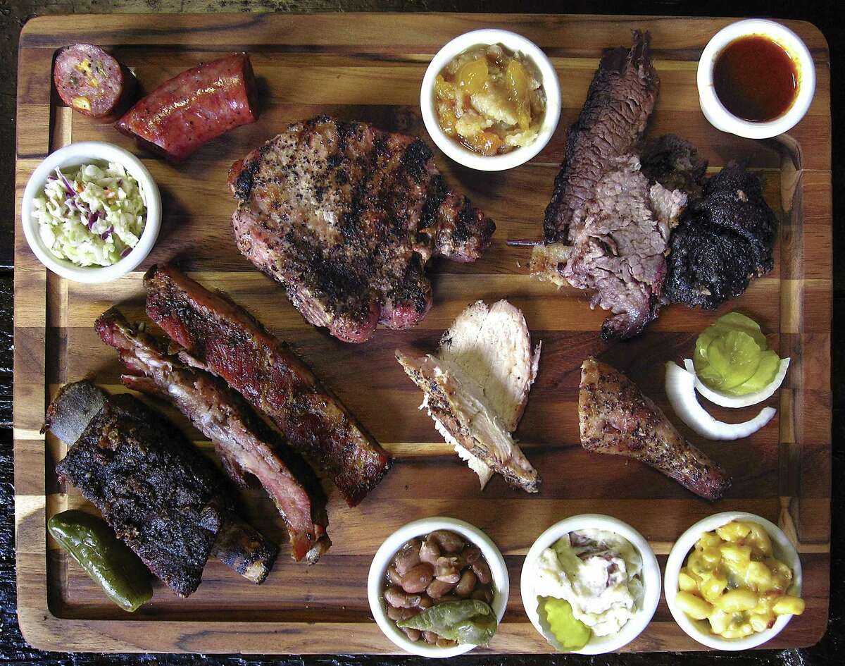Barbecue and sides from Cooper's Old Time Pit Bar-B-Que in New Braunfels. Clockwise from top left: jalapeño-cheese and regular sausage, pork chop, peach cobbler, brisket, barbecue sauce, smoked chicken, mac and cheese, potato salad, beans, beef rib, pork ribs, cole slaw and turkey.
