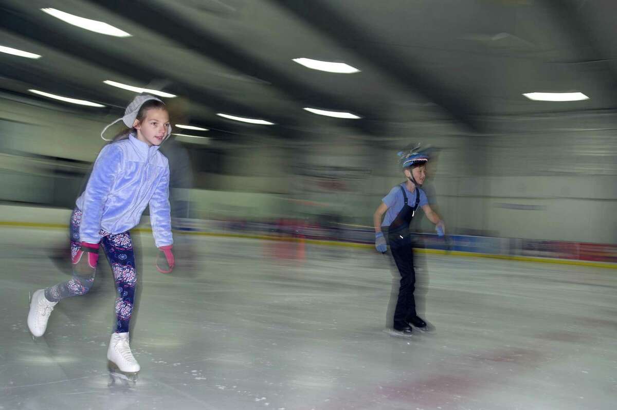 10-year-old Elaina Nowik of Norwalk, left, and nine-year-old Kane Duggar of New Canaan, zip around the ice together during the youth summer camp at Stamford Twin Rinks on Hope St. in Stamford, Conn. on Thursday, July 12, 2018.