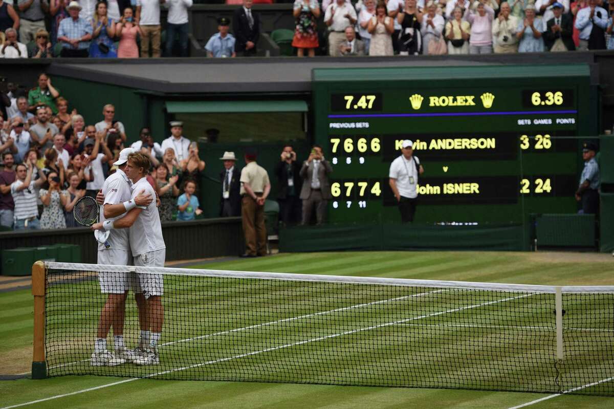 South Africa's Kevin Anderson (R) embraces US player John Isner after winning their men's singles semi-final match on the eleventh day of the 2018 Wimbledon Championships at The All England Lawn Tennis Club in Wimbledon, southwest London, on July 13, 2018. Anderson won the match 7-6, 6-7, 6-7, 6-4, 26-24. / AFP PHOTO / Oli SCARFF / RESTRICTED TO EDITORIAL USEOLI SCARFF/AFP/Getty Images