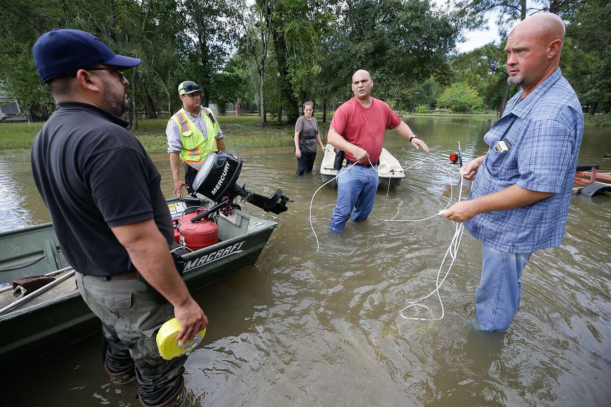 Robert Spooner, a US Customs and Border patrol officer, from Tomball, center, and other volunteers work to prepare boats to help people in the Lakewood area along Cypresswood Wednesday, August 30, 2017 in Houston. Much of the Houston area was flooded in the aftermath of Hurricane Harvey. ( Melissa Phillip / Houston Chronicle)
