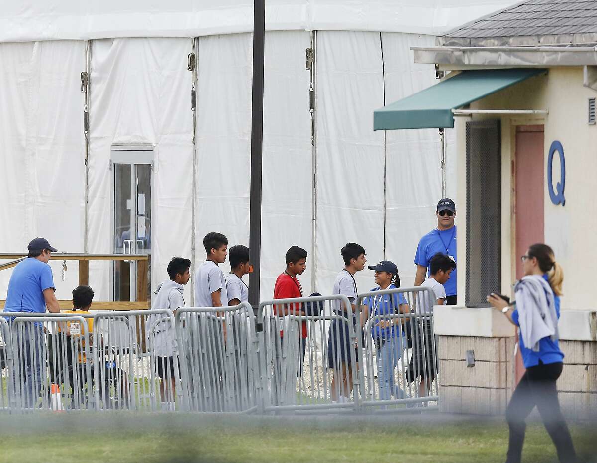 FILE - In this June 20, 2018, file photo, immigrant children walk in a line outside the Homestead Temporary Shelter for Unaccompanied Children a former Job Corps site that now houses them in Homestead, Fla. The landmark court case that has provided the framework for how the government can detain immigrant children has been cited by both sides of the debate over the separation of families at the border. The 1997 settlement known as the Flores agreement has been litigated off and on for the past 33 years and is a crucial piece of the puzzle for the administration's immigration enforcement policies. (AP Photo/Brynn Anderson, File)