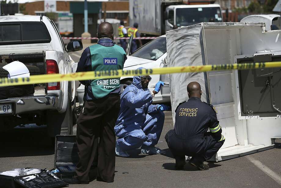   A forensic team looks for clues at the scene of a burglary in 2014 in Johannesburg. Criminal syndicates are accused of a sharp increase in attacks this year. Photo: Associated Press 