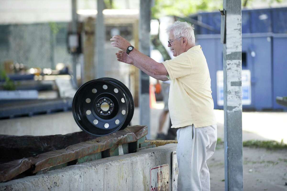Stamford resident Bruce Huffine throws a wheel disc into a dumpster at the Mygatt Recycling Center on Magee Ave. in Stamford, Conn. on Thursday, July 12, 2018. The city just renegotiated its contract with the recycling company it uses and now the budget will take an unexpected $700,000 hit.