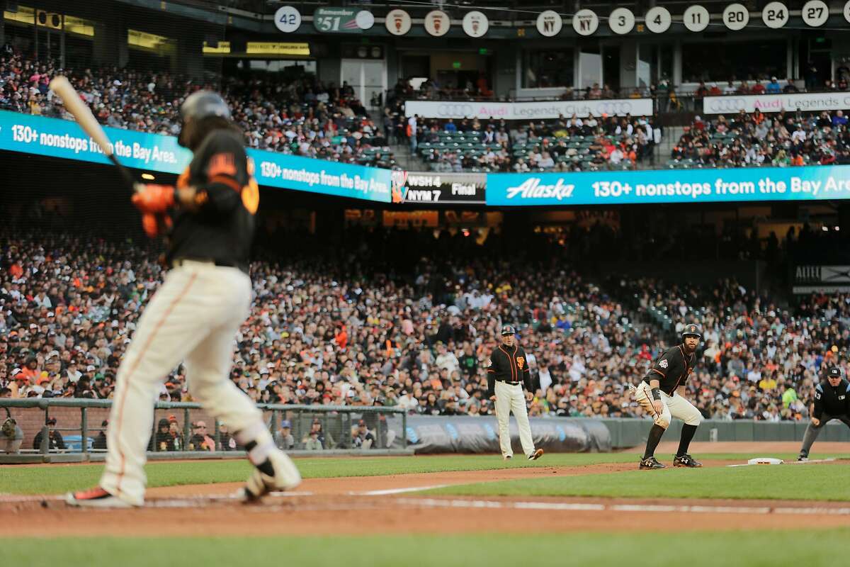 San Francisco Giants Brandon Belt (9) at third base watches as Giants Brandon Crawford (35) gets hit by a pitch during the second inning of an MLB game between the San Francisco Giants and Oakland Athletics at AT&T Park on Saturday, July 14, 2018, in San Francisco, Calif.