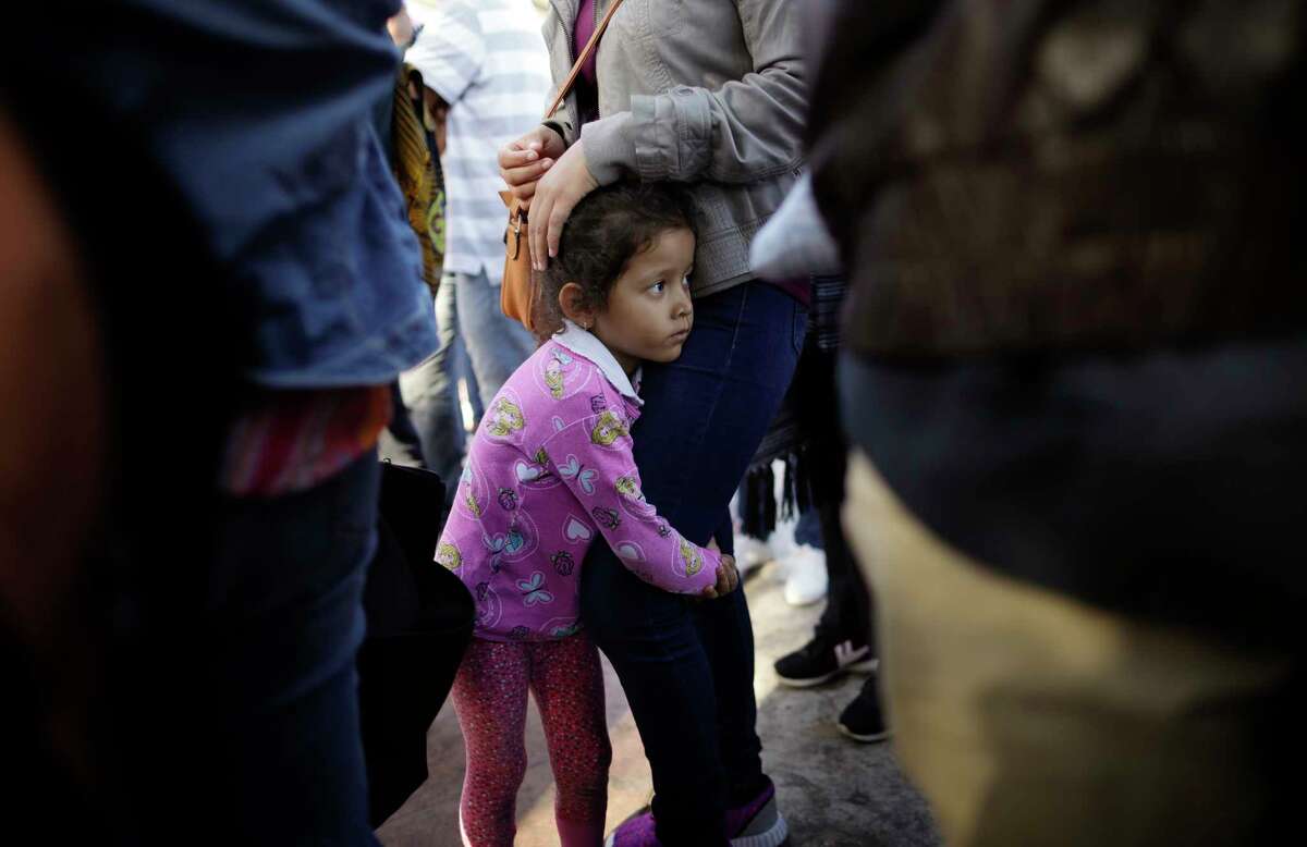 FILE - In this June 13, 2018 file photo, Nicole Hernandez, of the Mexican state of Guerrero, holds on to her mother as they wait with other families to request political asylum in the United States, across the border in Tijuana, Mexico. he separation of families at the U.S.-Mexico border caught the attention of the world and prompted mass outrage, but it only tells a small part of the story surrounding the Trump administration?’s immigration policy. (AP Photo/Gregory Bull, file)