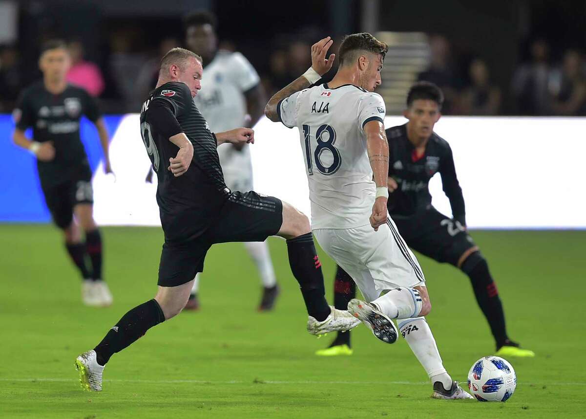 Wayne Rooney (L) of DC United vies for the ball with Jose Aja from the Vancouver Whitecaps FC during their match in Washington DC on July 14, 2018. / AFP PHOTO / ANDREW CABALLERO-REYNOLDSANDREW CABALLERO-REYNOLDS/AFP/Getty Images