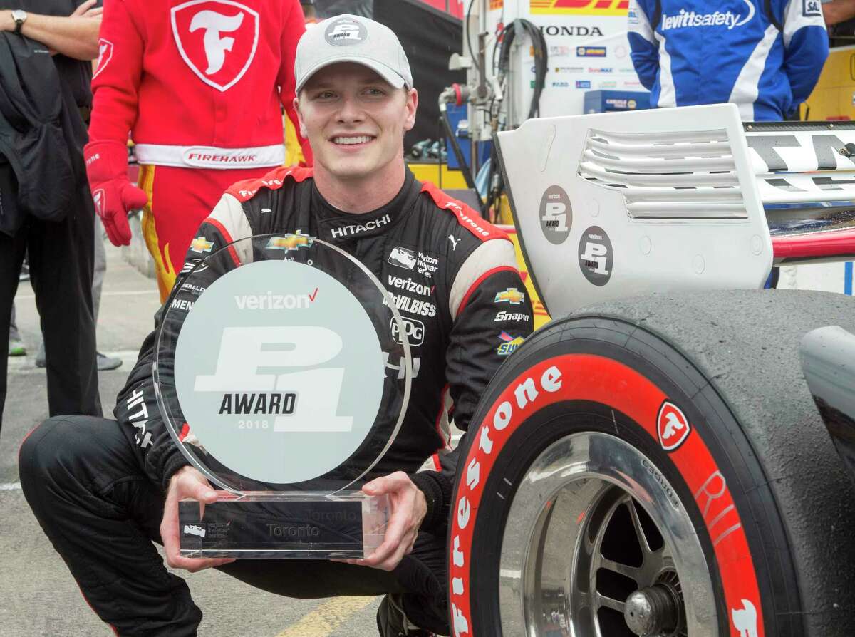 Josef Newgarden poses with the trophy after posting the fastest time during qualifying for the IndyCar auto race in Toronto on Saturday, July 14, 2018. (Frank Gunn/The Canadian Press via AP)
