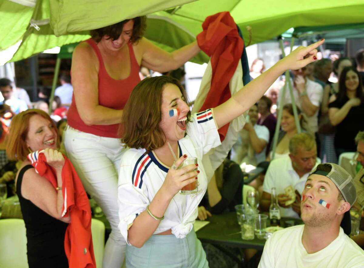 France fans, from left, Florence Chang, of Norwalk, Caroline Menchero, of Norwalk, Andrea Menchero, of Brooklyn, N.Y., and Ryan Graham, of West Hartford, celebrate as time expires in France's 4-2 win over Croatia in the FIFA World Cup final viewing party outside of Capriccio Cafe in Stamford, Conn. Sunday, July 15, 2018. Enthustiastic fans flocked to the bars to watch as France beat Croatia 4-2 to win its second World Cup.