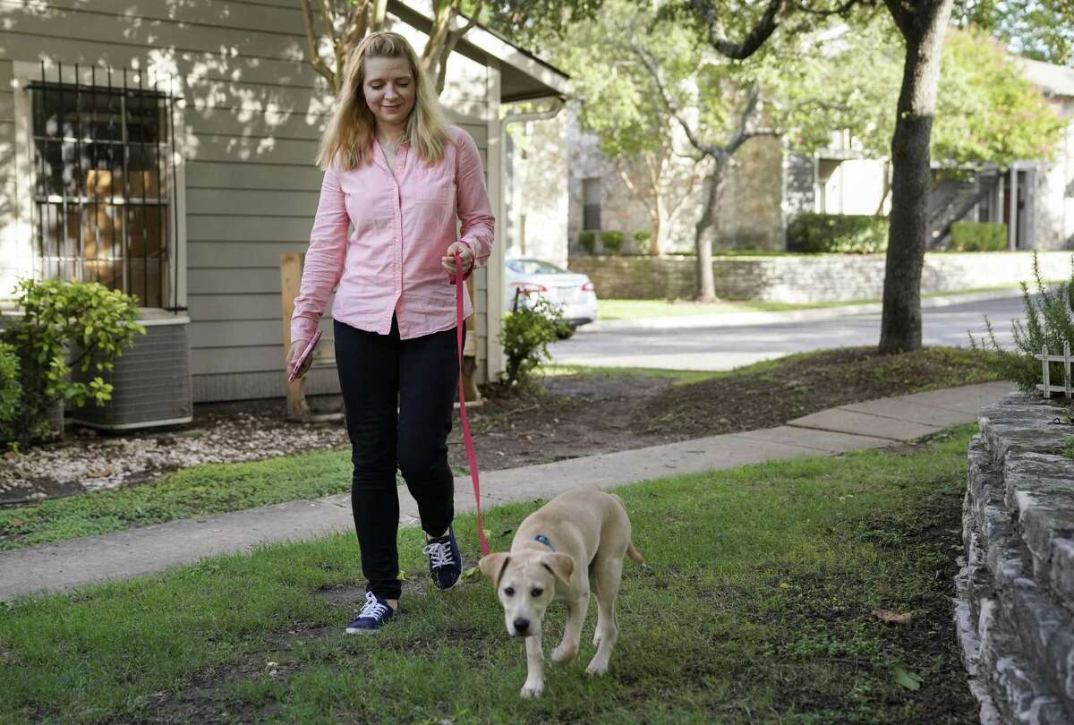 Pfc. Alina Kaliuzhna walks her puppy, Ivy, Tuesday, July 10, 2018, at her home in San Antonio. (Darren Abate/For the Express-News)