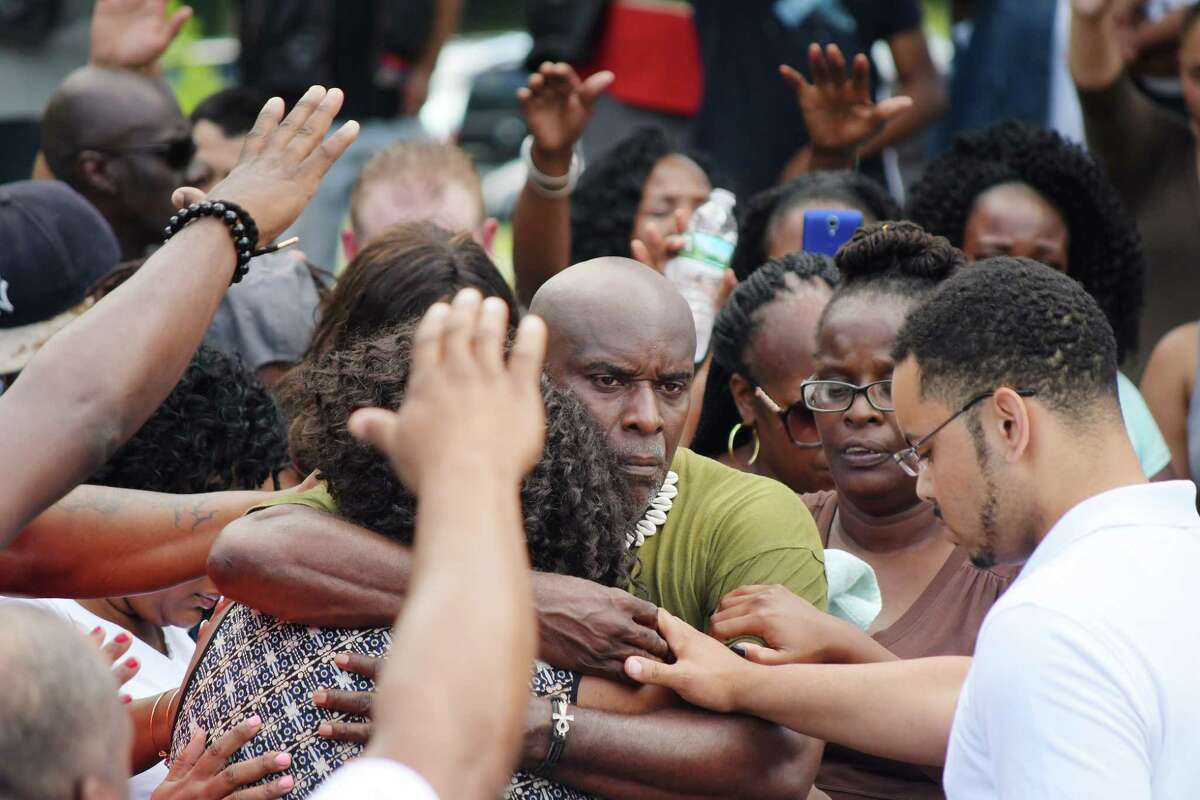 The mother of Khalil Barnes, Fatima Rucker, left, and his father, Justice Barnes, embrace each other as community members pray around them during a community meeting at Arbor Hill Park on Sunday, July 15, 2018, in Albany, N.Y. Khalil Barnes was killed early Saturday morning in Albany. (Paul Buckowski/Times Union)
