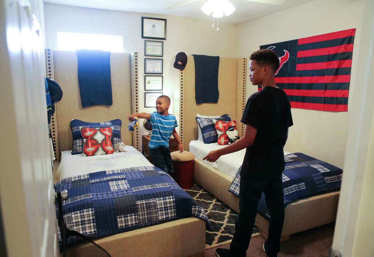 Arica Bibbs' sons explore their newly furnished and re-designed room in their apartment after a makeover from the Houston chapter of Dwell with Dignity.