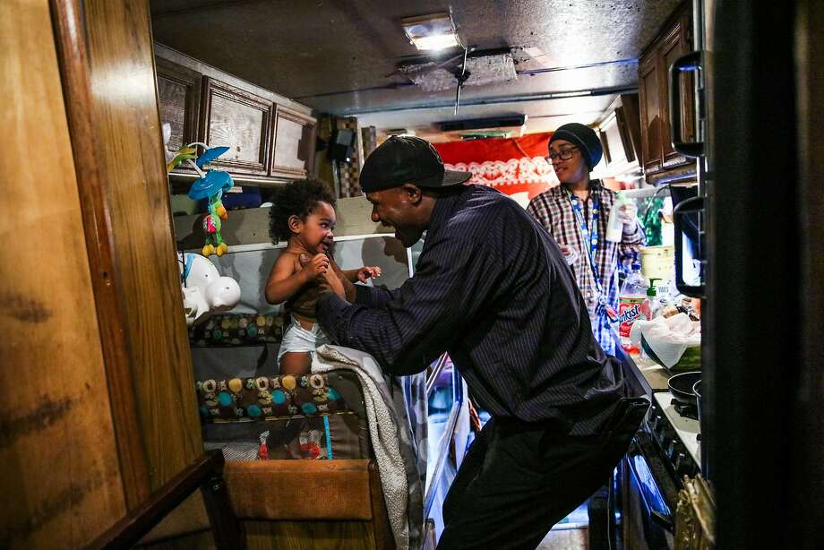 Arnell Clark plays with his son Arnez Clark, 1, while his girlfriend Mataele Robertson (right) gets his formula ready in their RV in East Palo Alto, California, on Thursday, July 12, 2018. They moved to an RV after their rent went up in 2015. Photo: Gabrielle Lurie / The Chronicle