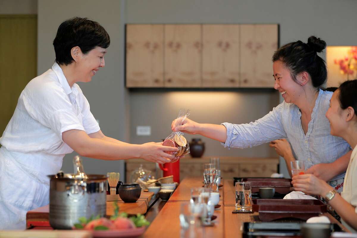 Anabel Lee, right, gives some cookies to Junko Schwesig during Oyatsuya, is a Sunday-afternoon pop-up by Schwesig, hosted at a sushi bar in San Francisco , Calif., on Sunday, July 15, 2018. Schwesig serves a multi-course tasting menu of Japanese sweets along with super-premium Japanese teas, including gorgeous little bites that are all about the peak of the season.