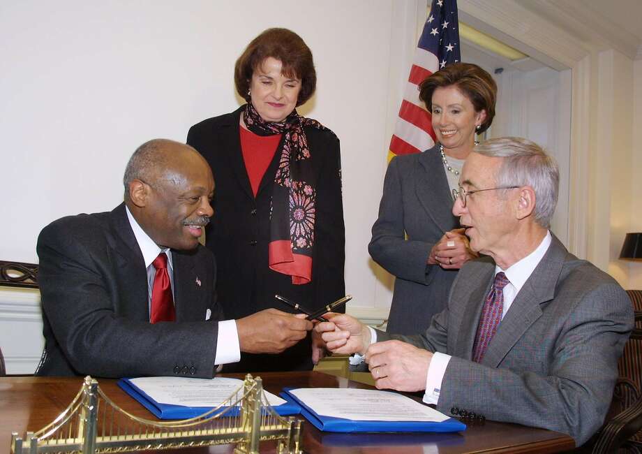 San Francisco Mayor Willie Brown exchanges pens with Navy Secretary Gordon England in Washington after signing an agreement with the Navy for a master plan for the cleanup of hazardous waste at the former Hunters Point Naval Shipyard, as Sen. Dianne Feinstein and Rep. Nancy Pelosi watch on Jan. 23, 2002. Photo: Terry Ashe / Associated Press 2002