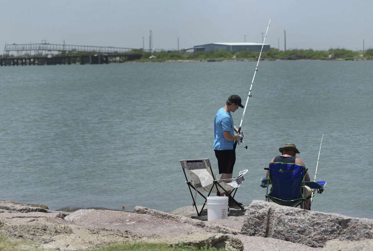 People fish at Port Aransas across the water from Harbor Island, visible in the distance. The Port of Corpus Christi wants to build its own crude oil export terminal capable of hosting Very Large Crude Carriers or VLCCs, and is opposing a plan by Swiss-commodity trader Trafigura to build an offshore export terminal.