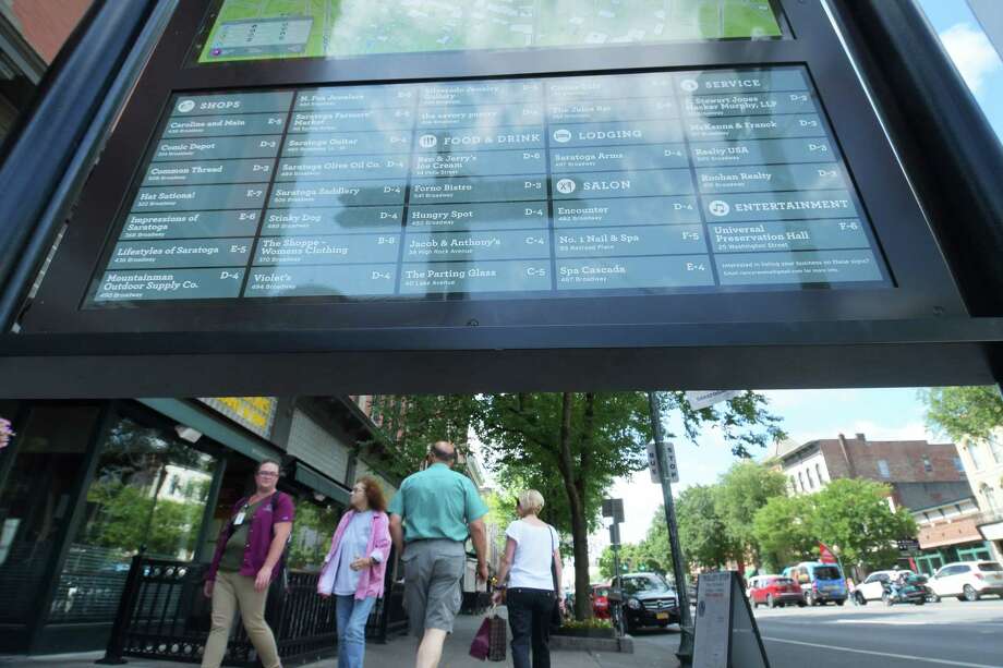Downtown businesses are listed on a sign as people walk along Broadway on Wednesday, July 18, 2018, in Saratoga Springs, N.Y. (Paul Buckowski/Times Union) Photo: Paul Buckowski, Albany Times Union / (Paul Buckowski/Times Union)