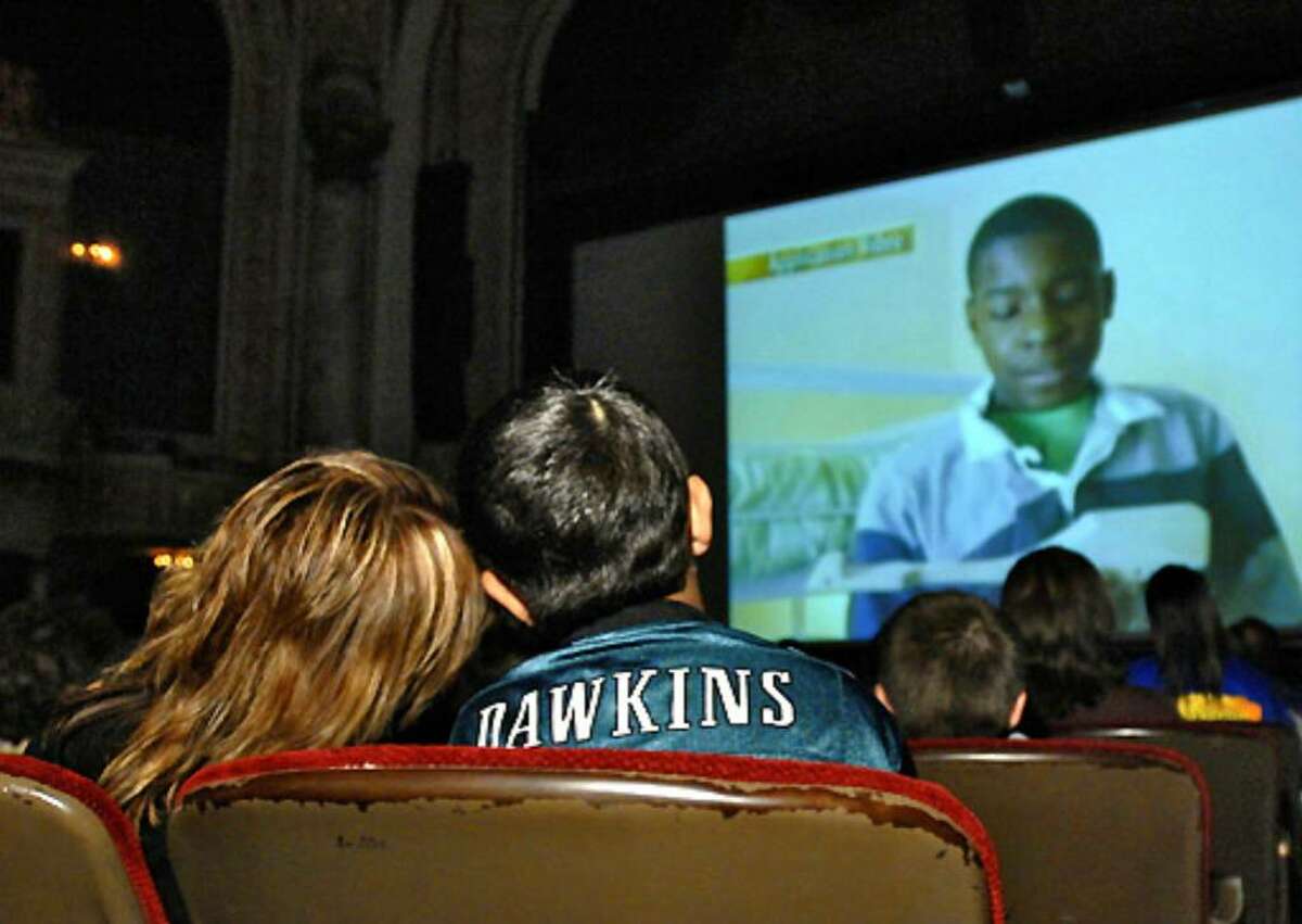 Debbie Oatman-Gaitan leans her head on her son Scout's shoulder while watching the 'Extreme Makeover' episode at Proctor's Theatre in Schenectady on Sunday.
