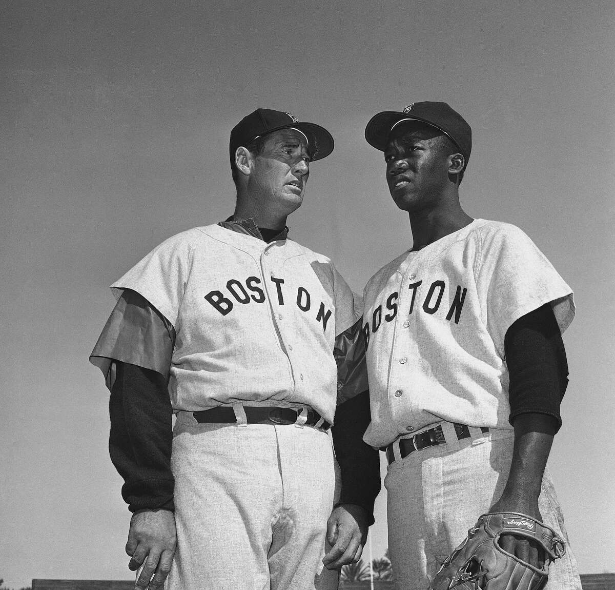 FILE - In this March 4, 1959, file photo, Ted Williams, long-time Red Sox batting ace, chats with E.J. (Pumpsie) Green at the Boston training camp in Scottsdale, Ariz. A new film explores the life of baseball legend Williams who struggled with his Mexican-American heritage and his volatile relationship with his family and the press. The upcoming PBS "American Masters" documentary on the former Boston Red Sox slugger uses rare footage and family interviews to paint a picture of a complicated figure that hid his past but later spoke out and defended black players. (AP Photo/Harold Filan, File)