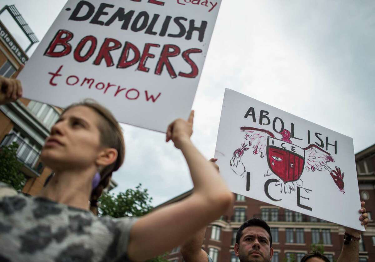 People hold up signs as they protest the U.S. Immigration and Customs Enforcement agency (ICE) and the recent detentions of illegal immigrants in Washington, D.C. on July 16. The coalition of activists called on the government to abolish ICE, a good slogan but a bad idea.
