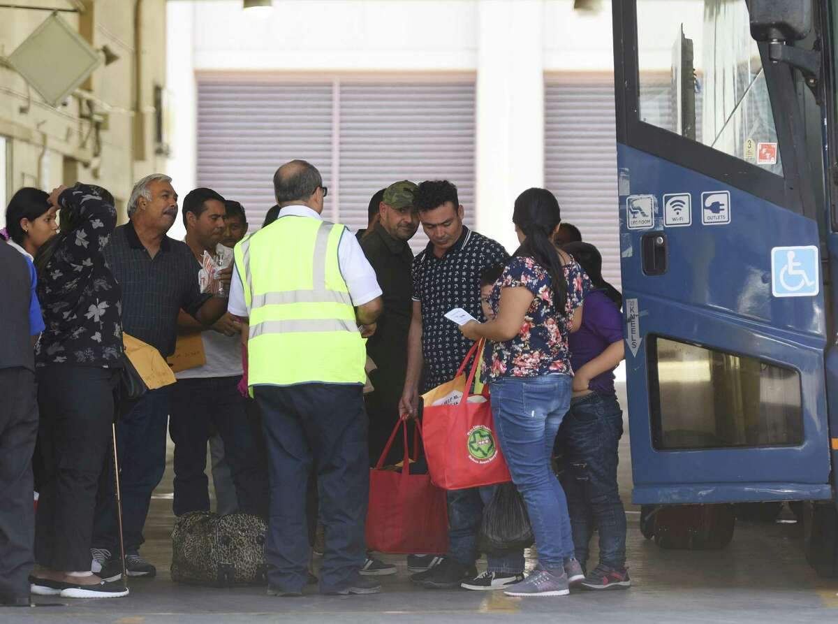 Immigrant families arrive at the San Antonio Greyhound bus station Thursday. Many will go on to other cities.