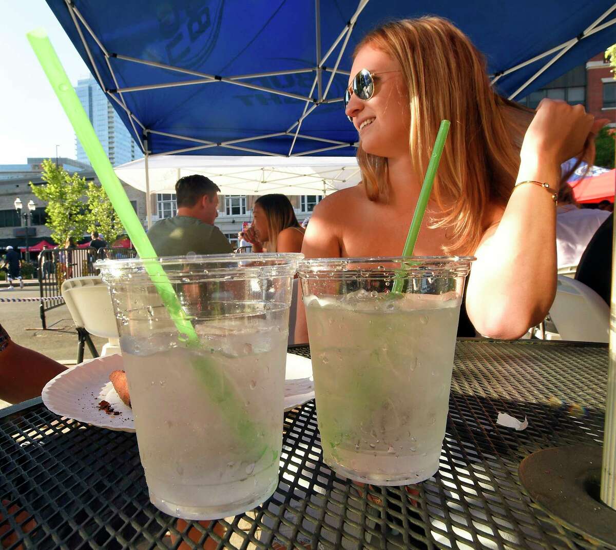 Kelsey Marioni of Stamford relaxes outside having a drink with a friend at Teena’s Apizza, a Stamford restaurant which opened last month, that only uses recyclable products, including totally compostable staws made from plant material, shown in a photograph taken on July 19, 2018 in Stamford, Connecticut.