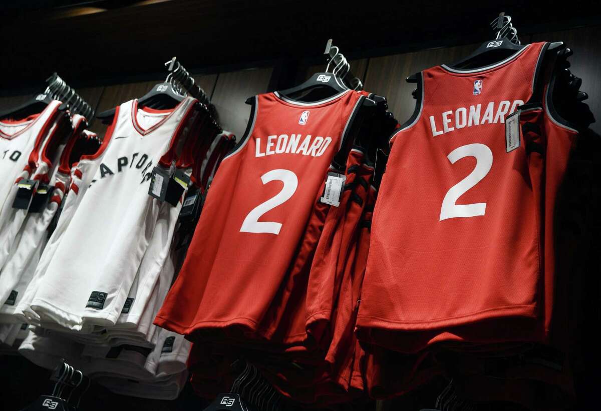 Days after the bombshell trade, NBA jerseys for newly-acquired Toronto Raptors player Kawhi Leonard hang in the Real Sports Apparel store at Scotiabank Arena in Toronto, Friday July 20, 2018.