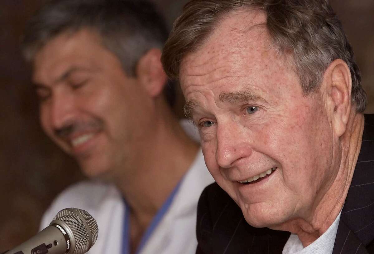 Former President George Bush, right, answers questions about his heart condition as cardiologist Mark Hausknecht laughs during a news conference at Methodist Hospital on Friday, Feb. 25, 2000 in Houston. Bush spent Thursday night in a Florida hospital and was released Friday after being treated for an irregular heartbeat. Doctors will investigate whether Bush's thyroid disorder, called Graves' disease, caused the irregularity. It was responsible for a similar episode he suffered while jogging in May 1991. (AP Photo/David J. Phillip)