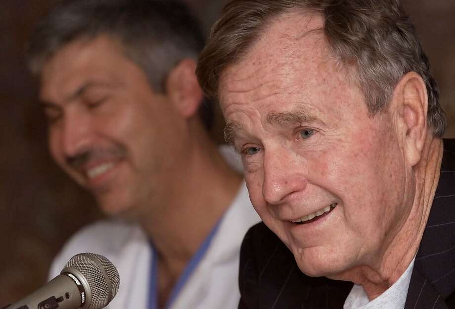   Ex-President George Bush, right, answers questions about his heart condition, as cardiologist Mark Hausknecht laughs at a press conference at the Methodist Hospital on Fridays February 25, 2000 in Houston. Bush spent Thursday night in a Florida hospital and was released Friday after being treated for an irregular heartbeat. Doctors will examine whether the thyroid disorder of Bush, called Graves' disease, caused the irregularity. He was responsible for a similar episode that he suffered while jogging in May 1991. (AP Photo / David J. Phillip) Photo: DAVID J. PHILLIP / AP / 2000 AP 