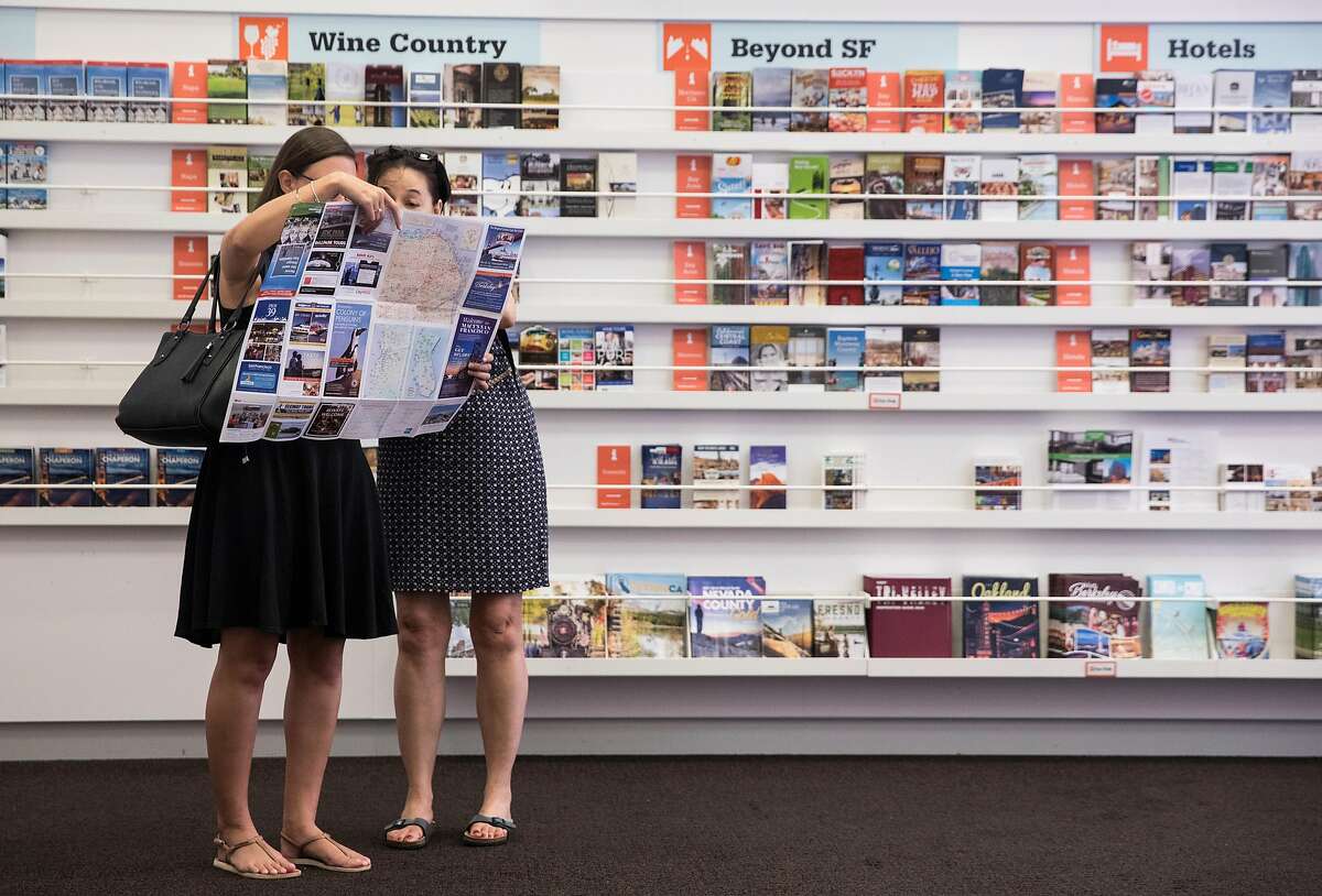 Two French tourists look over a map of San Francisco while at the San Francisco Visitor Information Center near Union Square in San Francisco, Calif. Friday, July 20, 2018.